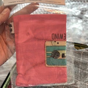 Face mask with a picture of a cassette on it, and a carrying bag